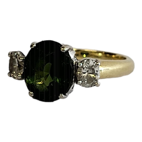 20 - AN 18CT GOLD, TOURMALINE AND DIAMOND RING
The central oval cut green tourmaline flanked by oval cut ... 