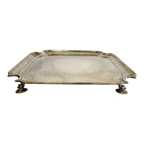 6 - AN EARLY 20TH CENTURY SILVER SALVER
Square form with cut corners and four scrolled legs, hallmarked ... 