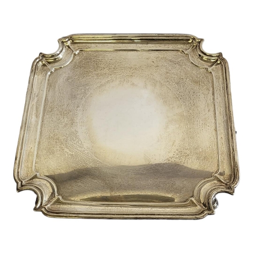 6 - AN EARLY 20TH CENTURY SILVER SALVER
Square form with cut corners and four scrolled legs, hallmarked ... 