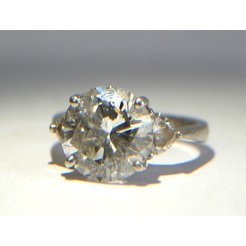 17 - A PLATINUM AND 4CT DIAMOND RING 
The round cut principle stone flanked by heart form diamonds to sho... 