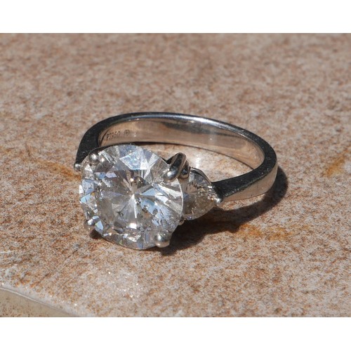 17 - A PLATINUM AND 4CT DIAMOND RING 
The round cut principle stone flanked by heart form diamonds to sho... 