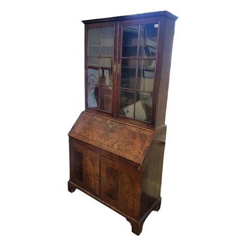 504 - AN EARLY 18TH CENTURY WALNUT BUREAU BOOKCASE
With two glazed doors above a fall front writing sectio... 