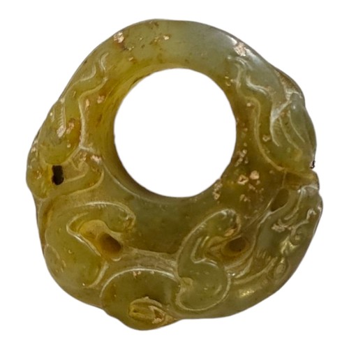 121 - A CHINESE GREEN JADE ARCHERS RING
Carved with a mythical beast.
(5.3cm)

Condition: good overall