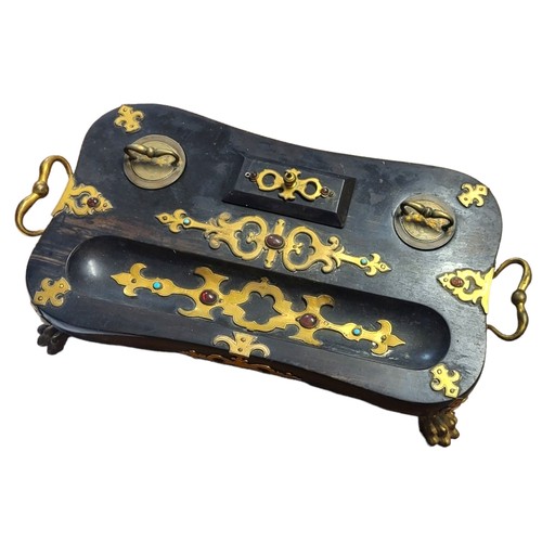 322 - A LATE VICTORIAN GOTHIC REVIVAL EBONISED STANDISH DESK/INKSTAND 
Gilded brass overlaid with two ink ... 