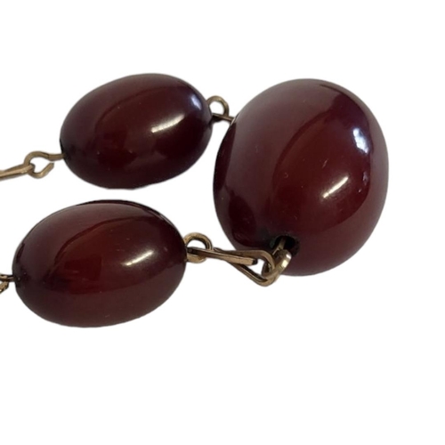 84A - A YELLOW METAL AND CHERRY AMBER NECKLACE
Having a row of graduated oval beads with yellow metal link... 