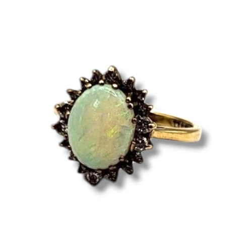 16B - A VINTAGE 9CT GOLD, OPAL AND DIAMOND RING
The oval cut opal edged with diamonds,
(approx total diamo... 