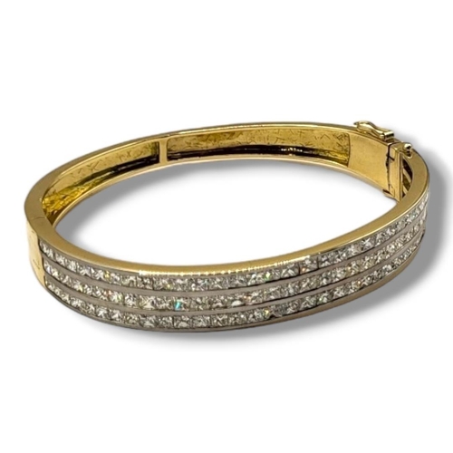 21B - A YELLOW METAL AND DIAMOND BANGLE
Set with three rows of princess cut diamonds.
(approx total diamon... 