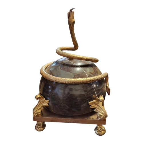 354 - A GILT METAL CENTREPIECE OF A SERPENT ENTWINING A MARBLE BALL 
Held by gilded acanthus leaves, raise... 