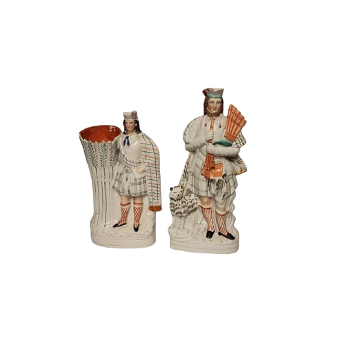 236 - A VICTORIAN STAFFORDSHIRE FLATBACK FIGURE MODELLED AS A SCOTTISH PIPE PLAYER AND DOG COMPANION 
A la... 