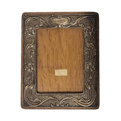 30 - AN ART NOUVEAU SILVER PHOTOGRAPH FRAME
Embossed organic form on oak easel back frame, hallmarked Wil... 