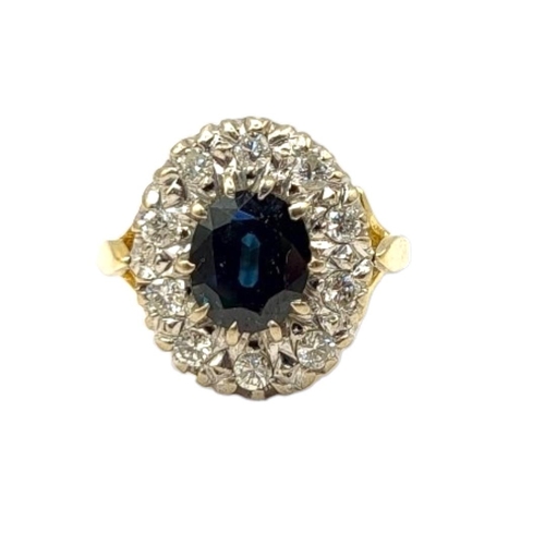 64 - AN 18CT GOLD, SAPPHIRE AND DIAMOND CLUSTER RING
The central oval cut sapphire edged with round cut d... 