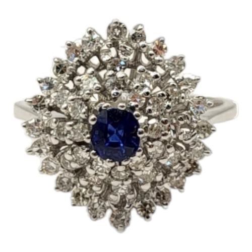 65 - AN 18CT WHITE GOLD, SAPPHIRE AND DIAMOND CLUSTER RING
The central round cut sapphire,edged with thre... 