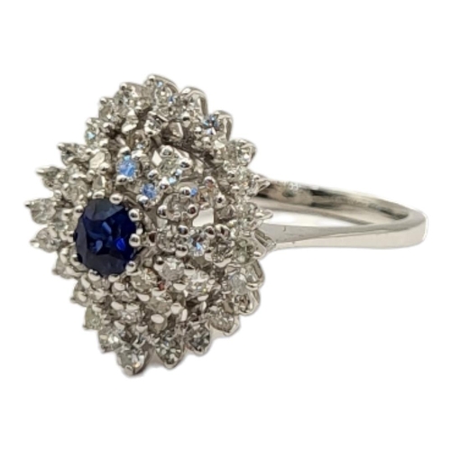 65 - AN 18CT WHITE GOLD, SAPPHIRE AND DIAMOND CLUSTER RING
The central round cut sapphire,edged with thre... 