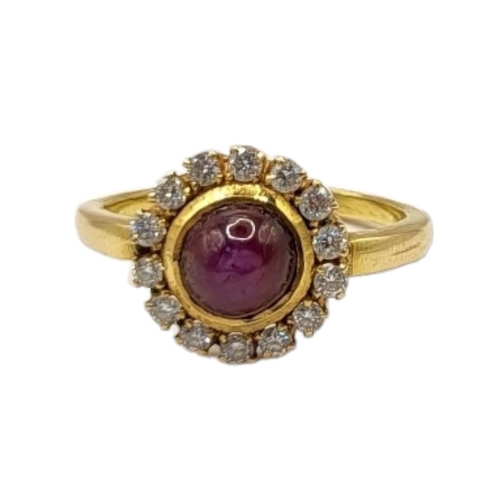 67 - A VINTAGE YELLOW METAL, STAR RUBY AND DIAMOND AND CLUSTER RING
The cabochon cut ruby edged with roun... 