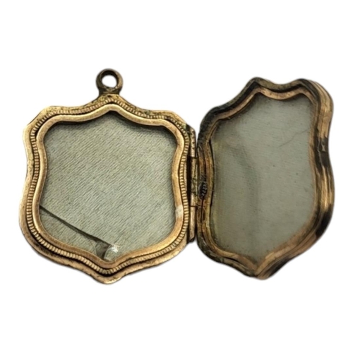 89 - A VICTORIAN GILT METAL AND HARDSTONE PENDANT LOCKET
Shield form with engraved decoration and glazed ... 