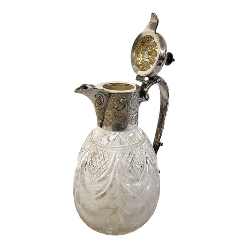 138 - A VICTORIAN SILVER PLATE AND CUT LEAD CRYSTAL CLARET JUG
Having a single carry handle embossed with ... 