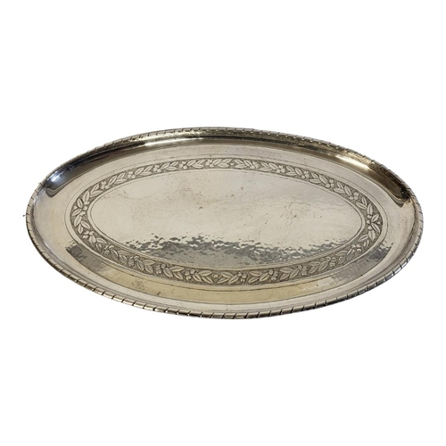 26A - AN ARTS AND CRAFTS SILVER PLATED OVAL SERVING TRAY 
Having a hammered planished finish with engraved... 