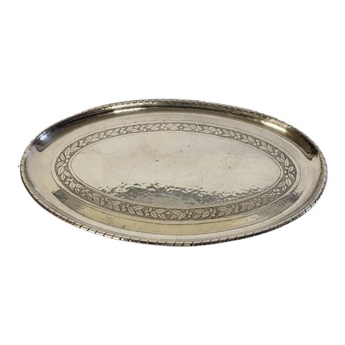 26A - AN ARTS AND CRAFTS SILVER PLATED OVAL SERVING TRAY 
Having a hammered planished finish with engraved... 