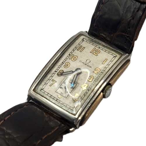 104 - OMEGA, AN EARLY 20TH CENTURY STAINLESS STEEL AND 9CT GOLD TANK GENT’S WRISTWATCH
Rectangular form wi... 