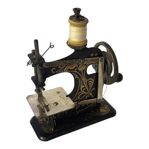 14 - MULLER, A 19TH CENTURY GERMAN TIN PLATE MINIATURE TOY SEWING MACHINE
Having gilt scrolled decoration... 