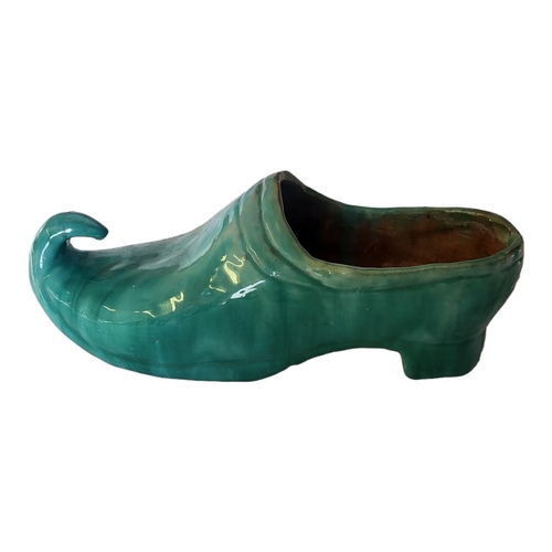 173 - AN EARLY 20TH CENTURY CONTINENTAL NOVELTY EARTHENWARE MODEL OF A CLOG
Covered with light green lustr... 