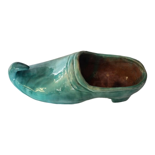 173 - AN EARLY 20TH CENTURY CONTINENTAL NOVELTY EARTHENWARE MODEL OF A CLOG
Covered with light green lustr... 