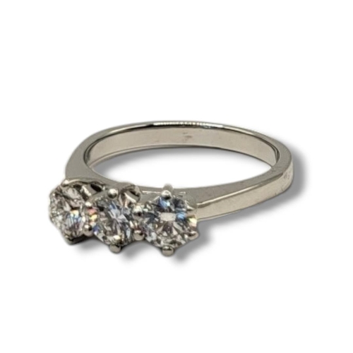 1A - A PLATINUM AND DIAMOND THREE STONE RING
The round cut diamonds in plain platinum mount,together with... 