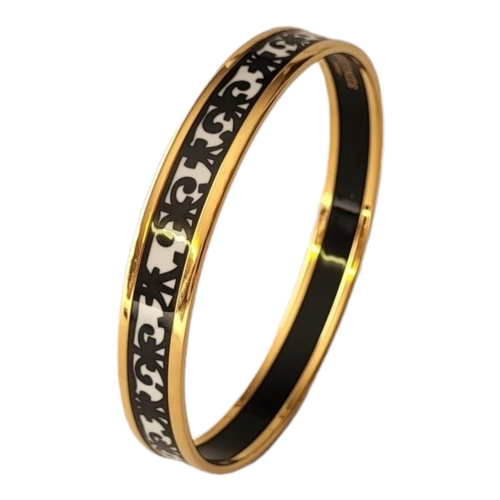 28 - HERMÈS, A VINTAGE GOLD PLATE AND ENAMEL BANGLE
Having a fleur-des-lis design, marked ‘Hermès, Paris’... 