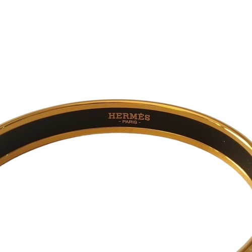 28 - HERMÈS, A VINTAGE GOLD PLATE AND ENAMEL BANGLE
Having a fleur-des-lis design, marked ‘Hermès, Paris’... 