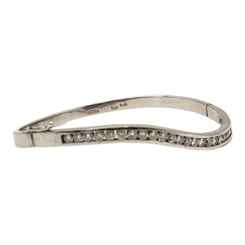 4A - PETER, AN 18CT WHITE GOLD AND DIAMOND BANGLE
The row of round cut diamonds in a wave design, marked ... 