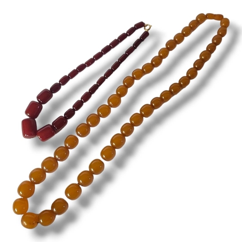 5 - A 20TH CENTURY CHERRY AMBER BEAD NECKLACE
Graduated cylindrical beads with yellow metal clasp, toget... 