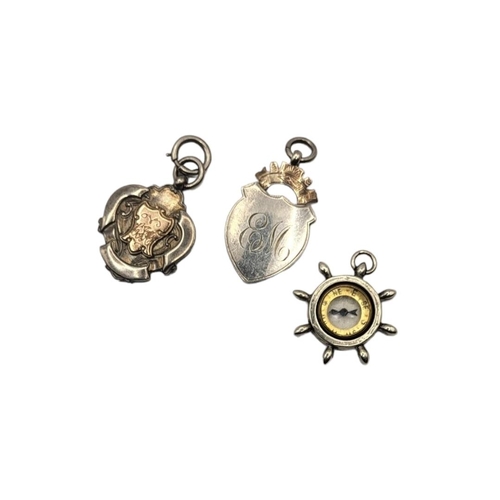 50 - A COLLECTION OF THREE VINTAGE SILVER POCKET WATCH FOBS
To include a compass ship's wheel and a fob w... 