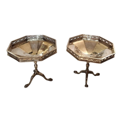 53A - A PAIR OF EARLY 20TH CENTURY SILVER OCTAGONAL SWEETMEAT DISHES
With pierced border and tripod legs, ... 