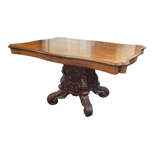 606 - A 19TH CENTURY MAHOGANY DINING TABLE
With cartouche top, raised on a heavily carved pedestal, with f... 