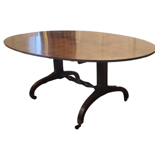 611 - A GEORGIAN SOLID MAHOGANY DINING TABLE
The oval tilt top with reeded border, raised on two columns w... 