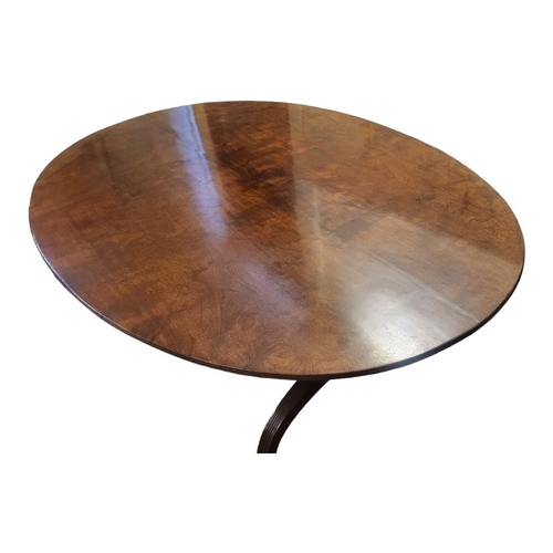 611 - A GEORGIAN SOLID MAHOGANY DINING TABLE
The oval tilt top with reeded border, raised on two columns w... 