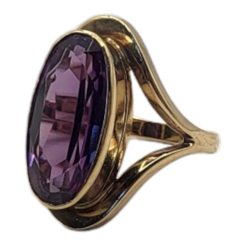 63 - A VINTAGE 9CT GOLD AND AMETHYST RING
The oval cut stone in a pierced mount.
(size N)

Condition: goo... 