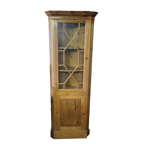 586 - A 19TH CENTURY STYLE PINE FLOOR STANDING CORNER CABINET
The single astragal glazed door above cupboa... 