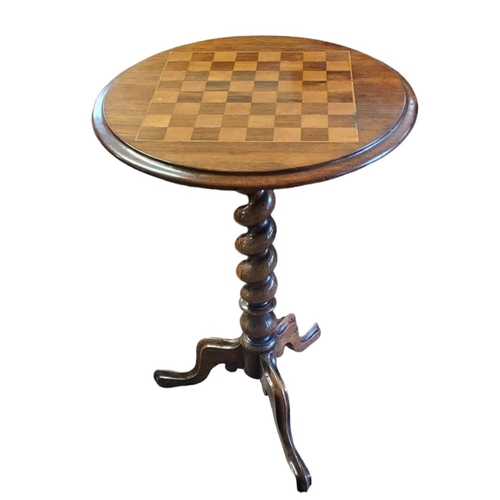 588 - A VICTORIAN ROSEWOOD GAMES/OCCASIONAL TABLE
The circular top with marquetry inlaid checkerboard play... 