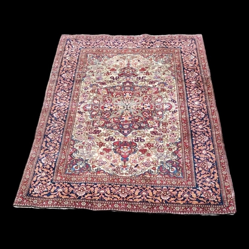 595 - A VINTAGE PERSIAN WOOLLEN RUG
With central floral field contained in running borders on a red and bl... 