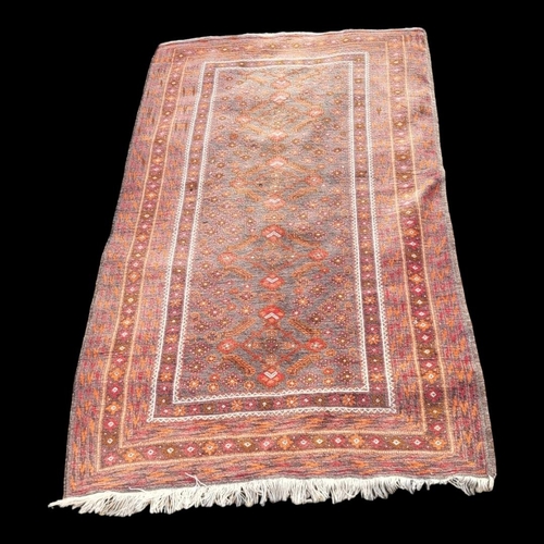 596 - A CAUCASIAN WOOLEN RUG
The central madder field within running orders.
(117cm x 214cm)

Condition: g... 