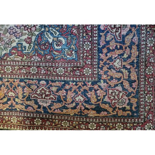 595 - A VINTAGE PERSIAN WOOLLEN RUG
With central floral field contained in running borders on a red and bl... 