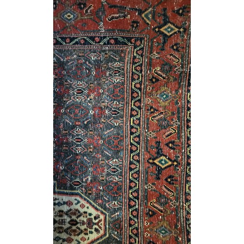 599 - A HERIZ WOOLLEN RUG
The central medallion contained within a madder field and running borders on red... 