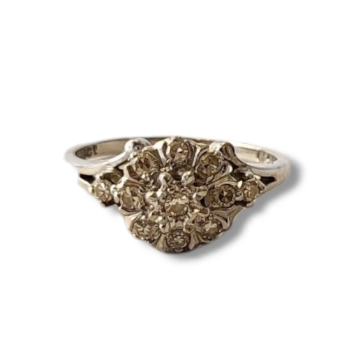 142 - A VINTAGE 18CT WHITE GOLD AND DIAMOND RING
Having an arrangement of round cut diamonds forming a dai... 