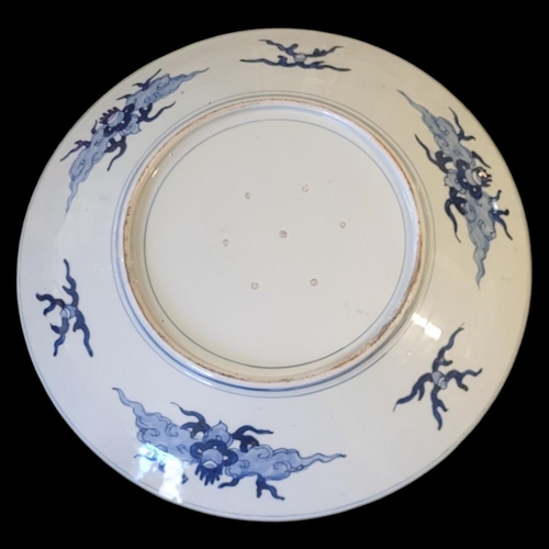 215 - A LARGE JAPANESE MEIJI BLUE AND WHITE CHARGER
Hand painted decoration of opposing dragons within clo... 