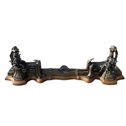 568 - A 19TH CENTURY FRENCH BRONZE FIGURAL CHENET
The serpentine rail cast with a central shell and leaves... 