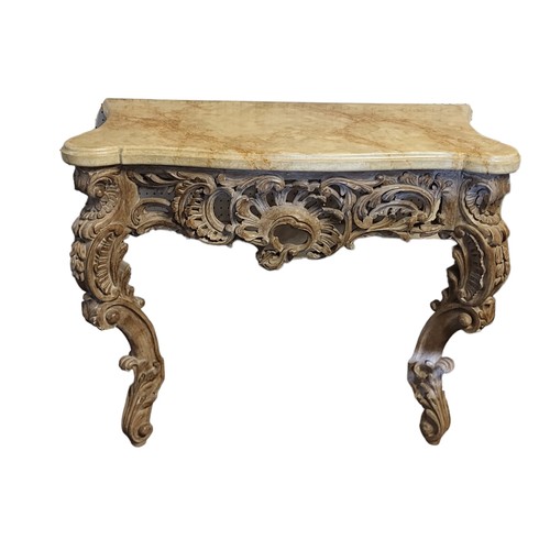 564 - AN 18TH CENTURY STYLE CARVED LIMED WOOD CONSOLE TABLE
With faux marble top above a pierced apron cen... 