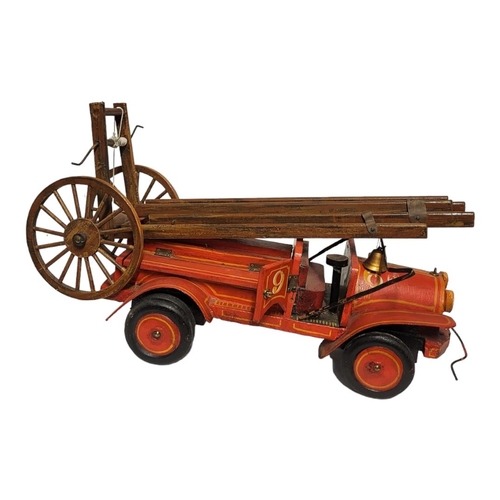 231 - A 20TH CENTURY CARVED WOODEN FIRE ENGINE
Having carved telescopic ladders and red hand painted liver... 