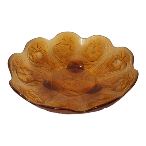 189 - AN EARLY 20TH CENTURY AMBER GLASS BOWL
Having a scalloped edge and embossed floral decoration to rev... 