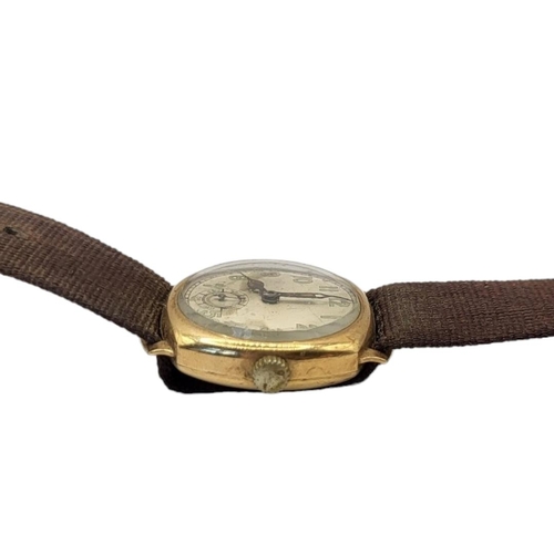 102 - AN EARLY 20TH CENTURY 9ct GOLD GENTS WRISTWATCH
Square form case on brown fabric strap, silver tone ... 